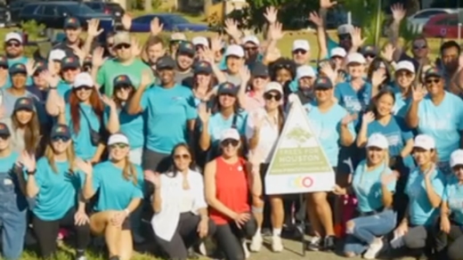 A group of people at an outdoor event smiling and waving